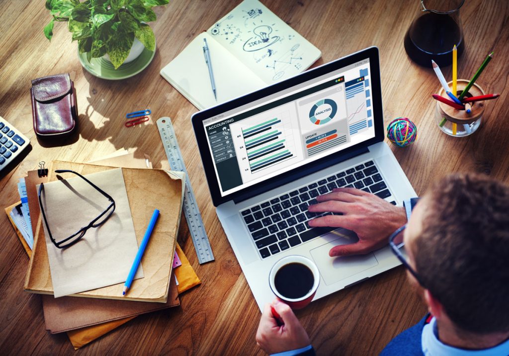 Overhead view of man working on laptop at desk.