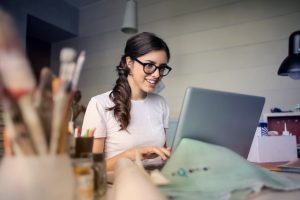 A woman smiling using her laptop.